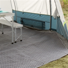 Grå geometrisk matta i tält med hopfällbart bord och bänk. Tältet är säkert uppsatt för camping.