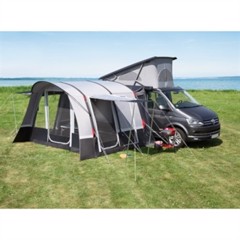 Tält anslutet till skåpbil på gräs vid ström, med fönster och ingång, redo för camping.